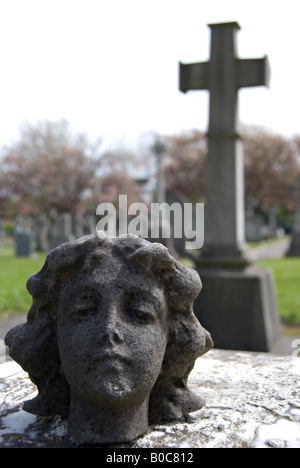 Chef de corps et de broken angel reposant sur pierre tombale, avec en arrière-plan, cimetière de Surbiton, Surrey, Angleterre Banque D'Images