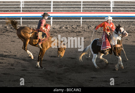 Image d'un homme monté sur un cheval alors que le tronçonnage bronc torero des tours en face de lui Banque D'Images