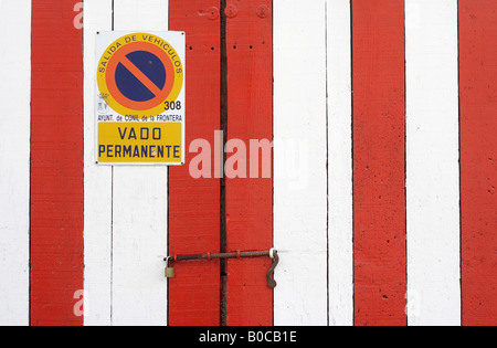 Porte de garage peint en blanc et rouge, Conil de la Frontera, Espagne Banque D'Images