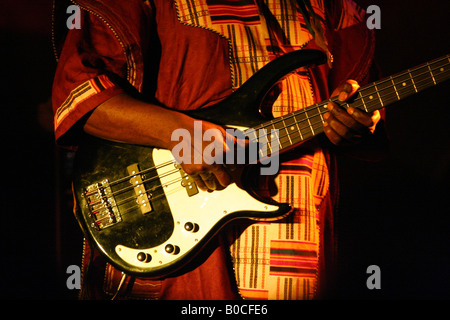 Musicien africain en costume traditionnel joue la guitare basse Banque D'Images