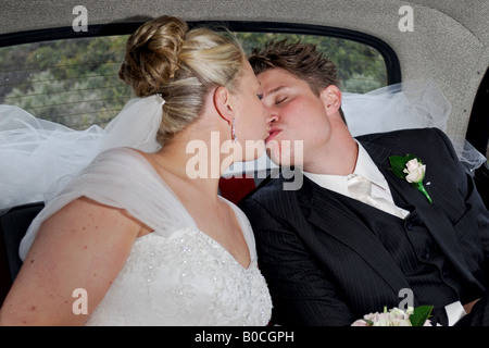Mariée et le marié s'embrasser dans une voiture de mariage Banque D'Images