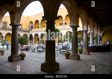 Cour intérieure de l'hôtel Camino Real de Puebla, Mexique. Entouré de colonnes antiques, le toit couvert par l'ombre de géant. Banque D'Images