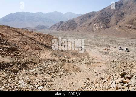 Voir des véhicules dans le wadi bed à partir de l'emplacement de ville romaine à Mons Porphyrites, les collines de la mer Rouge, Désert, Egypte Banque D'Images