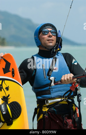 Un expert montres kite surfer le vent alors qu'il se prépare dans les vagues et l'eau d'une destination tropicale. Banque D'Images