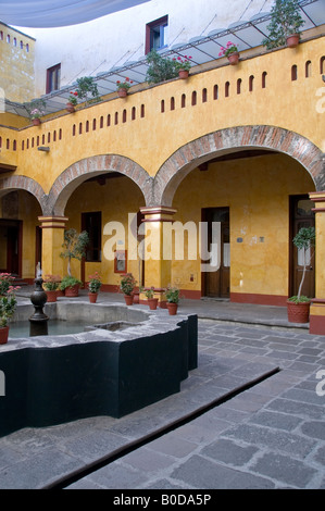 Cour intérieure de l'hôtel Camino Real de Puebla, Mexique. Entouré de colonnes antiques, le toit couvert par l'ombre de géant. Banque D'Images