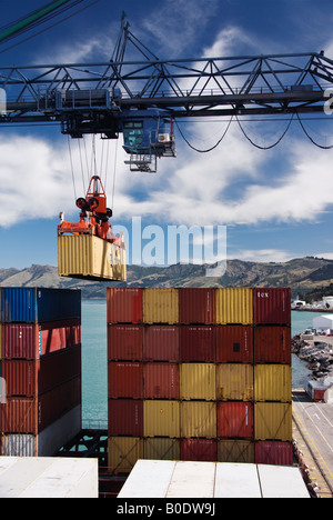 Une vue de piles de conteneurs sur un navire porte-conteneurs avec un récipient être soulevé par une grue. Banque D'Images