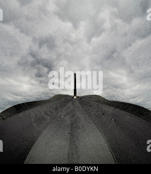 Au cours de la Pluie Pluie parapluie noir avec de sombres nuages de tempête Banque D'Images