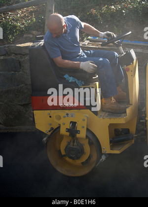 Les rouleaux de l'asphalte sur Workman fraîche allée nouvellement construits Banque D'Images