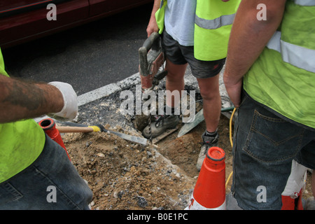 Ouvriers creusant le trou de road Banque D'Images