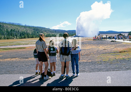 Les visiteurs se tiennent près de l'Old Faithful Geyser in Yellowstone Banque D'Images
