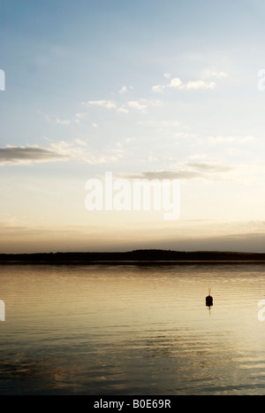 Bouée solitaire sur soirée sereine par lac calme avec des nuages sur fond de ciel bleu, Kalkkinen, Finlande Banque D'Images