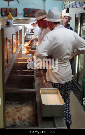 Les friteuses au travail dans un traditionnel fish and chip shop. Banque D'Images