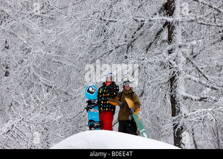 Les snowboarders Clark Murray et Jo Howard donnent sur scène alpine enneigée. Banque D'Images