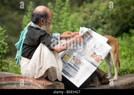 Homme âgé de Kerala s communauté malayali habillée de façon traditionnelle de la lecture d'un journal Mundu Malayalam Kerala Inde Banque D'Images