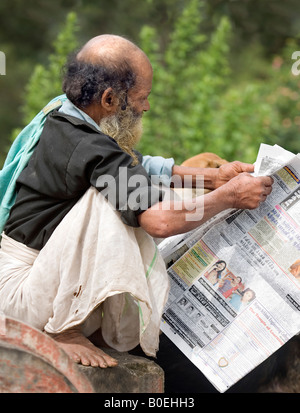 Homme âgé de Kerala s communauté malayali habillée de façon traditionnelle de la lecture d'un journal Mundu Malayalam Kerala Inde Banque D'Images