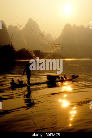 Rivière Li cormorant fisherman sur radeau en bambou pierres filet de pêche Banque D'Images