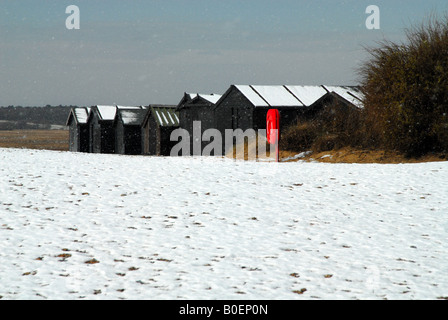 Cabines de plage à Walberswick dans la neige Banque D'Images