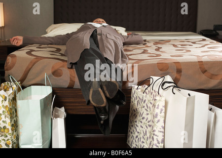 Young woman on bed with shopping Banque D'Images