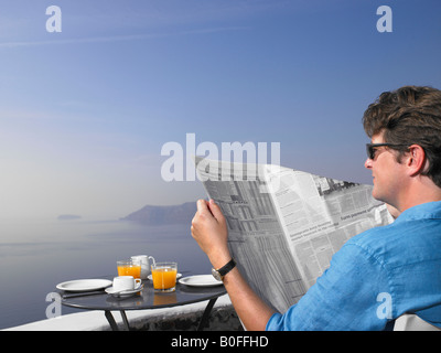 Man reading journal au petit déjeuner Banque D'Images