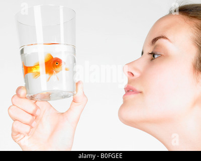 Femme regardant un poisson rouge Banque D'Images