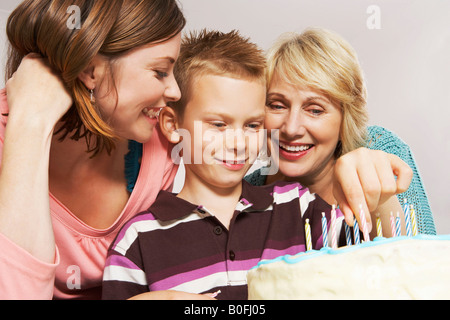 Garçon, grand-mère et maman decorating cake Banque D'Images