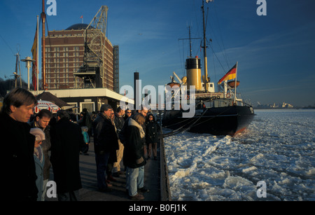 "Brise-glace" tettin historique, les personnes en attente de harbor ferry au Quai 'Neumuehlen', la glace flottante sur l'Elbe à Hambourg, Allemagne Banque D'Images