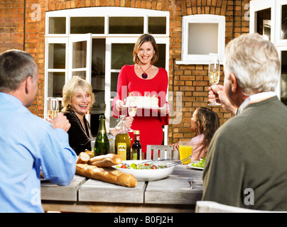 Femme portant le gâteau d'anniversaire à la table Banque D'Images