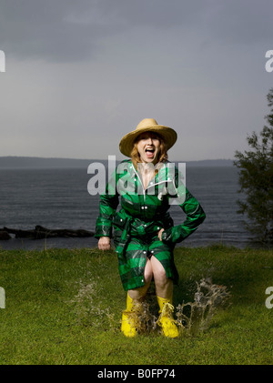 Femme sautant dans l'eau flaque Banque D'Images