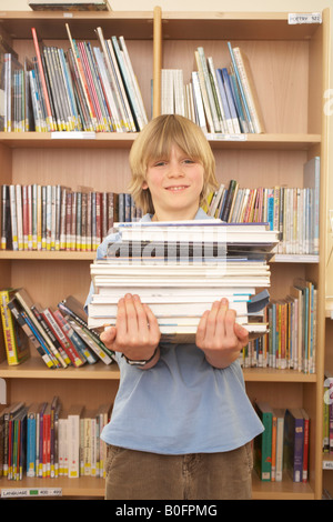 Boy carrying books, smiling Banque D'Images