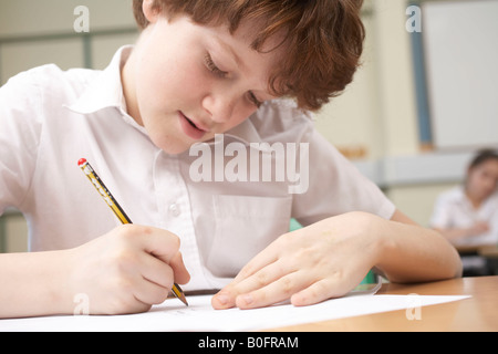 Boy écrit in classroom Banque D'Images