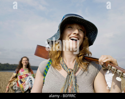 Femme marche avec guitare sur l'épaule Banque D'Images