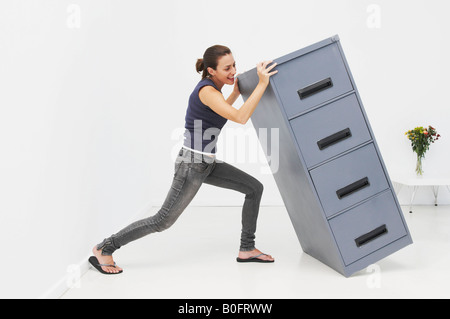 Femme lutte avec armoire de classement Banque D'Images