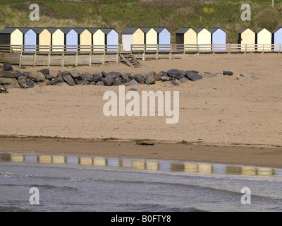 Une rangée de cabines de plage, et leur reflet dans le bord de la mer, sur la plage Summerleaze, Bude, Cornwall, UK Banque D'Images