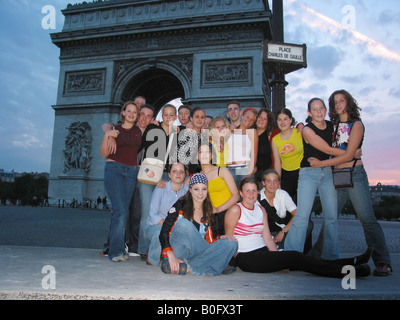 Un groupe d'étudiants posant devant l'Arc de Triomphe Paris France au crépuscule Banque D'Images