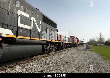 Un train de marchandises du Canadien National traverse un chemin rural dans le midwest des États-Unis près de Chicago. Banque D'Images