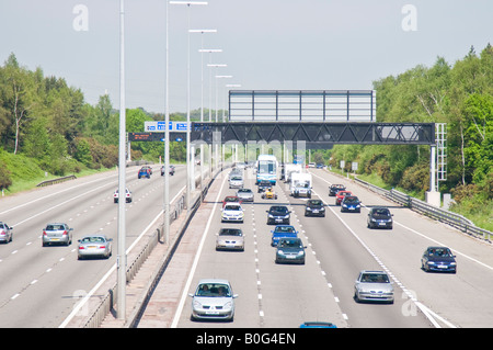 Le trafic sur l'autoroute M27, près de Southampton en Angleterre un jour normal montrant divers signes de marquage au sol et de portiques etc. Banque D'Images