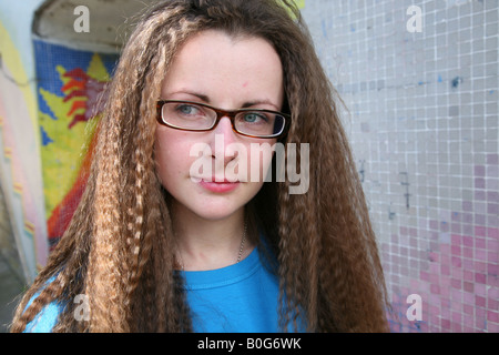 Caucasian female teenage student looking for trouble pris à l'extérieur dans un passage sous couvert de graffitis sur une propriété du conseil Banque D'Images