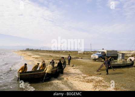 Les pêcheurs tirant un bateau sur la plage de la mer Caspienne, Lenkoran, Azerbaïdjan. Banque D'Images
