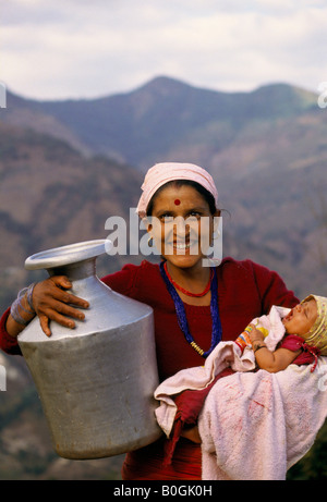 Une femme avec un bébé va recueillir l'eau d'un robinet, Chilaunebas, Népal. Banque D'Images