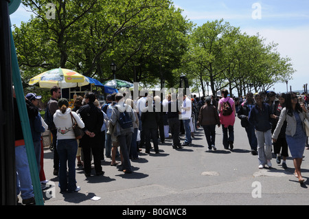 Un dimanche dans le sud de Manhattan une longue file de personnes attend à bord du ferry pour la Statue de la Liberté et Ellis Island. Banque D'Images