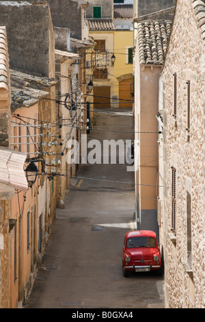 Une voiture rouge dans une rue tranquille de la vieille ville d'Alcudia à Majorque Espagne Banque D'Images