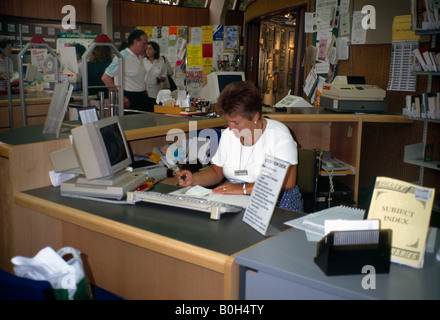 De Travail bibliothécaire sur ordinateur dans Library Numérisation livres Banque D'Images