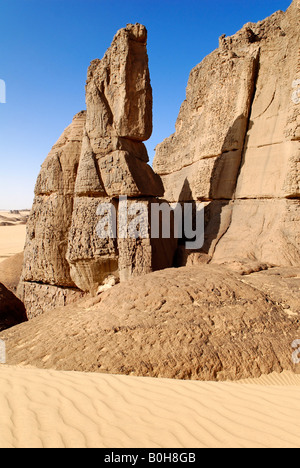 Des formations rocheuses érodées sortant de dunes de sable du désert dans la région de Tin Akachaker, Tassili du Hoggar, Tamanrasset Wilaya, désert du Sahara, Banque D'Images