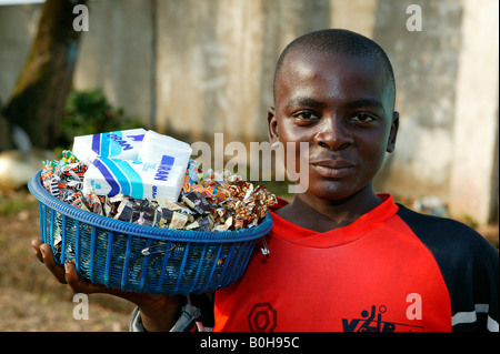 La vente des bonbons adolescent et des mouchoirs en papier à Douala, Cameroun, Afrique Banque D'Images