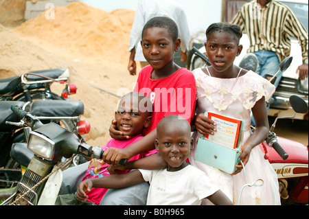 Quatre enfants assis sur un scooter Douala, Cameroun, Afrique Banque D'Images