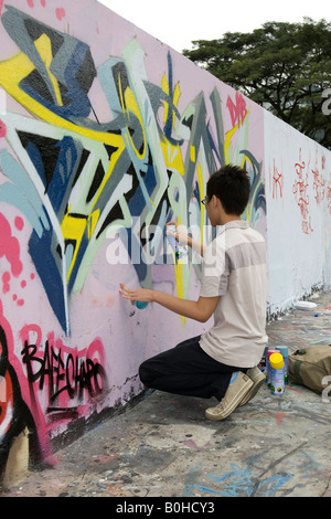 Pulvérisation garçon graffiti sur un mur à Singapour, en Asie du sud-est Banque D'Images