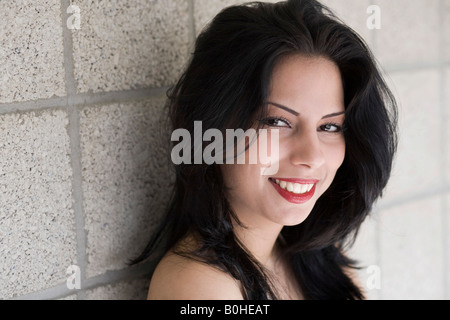 Portrait d'une jeune femme brune en face d'un mur Banque D'Images