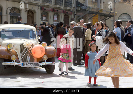 Les filles dans une fête de mariage danser devant une voiture antique décoré avec des ballons et des fleurs, la Plaza San Felipe, Saragosse ou Banque D'Images