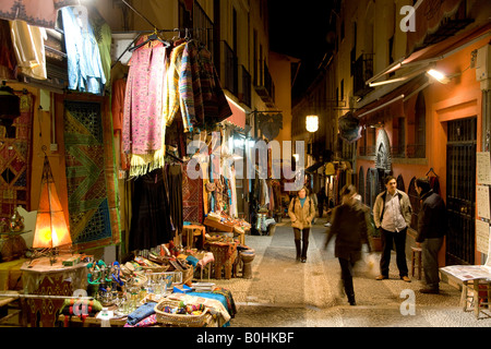 Maisons de thé, les touristes et les magasins de souvenirs vendant de l'artisanat marocain dans la nuit dans la pittoresque rue Caldereria Nueva, Grenade, Banque D'Images