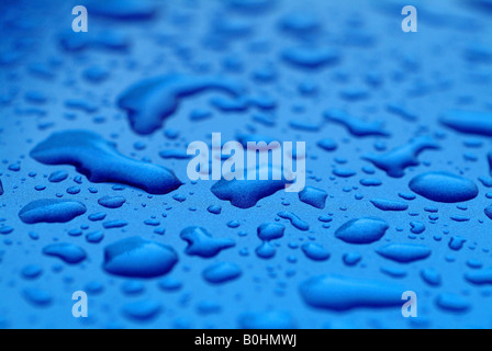 Gouttes d'eau, gouttes d'eau formées sur une surface bleue Banque D'Images